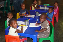 A group of children drawing at tables in a crèche