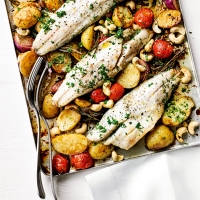 Baked sea bass with new potatoes, tomatoes & roasted cashews